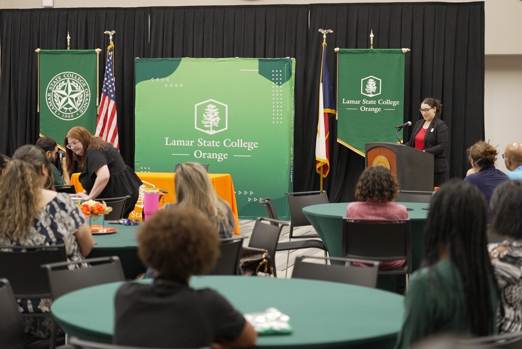LSCO Early College Signing Night, with speaker at podium and audience out of focus in foreground