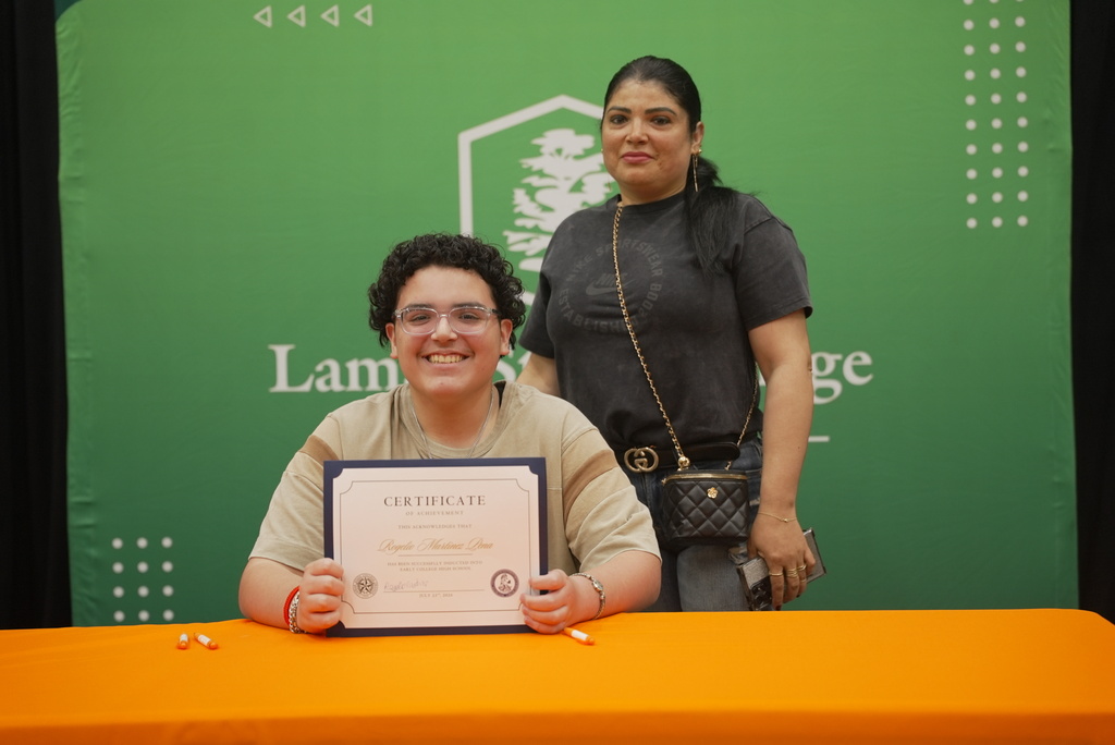 Students holding up LSCO signing certificate with mother standing beside