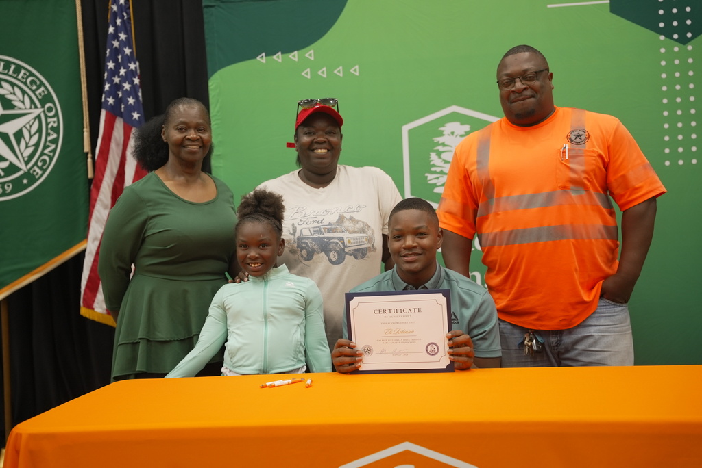 Family standing with student holding up Early College certificate