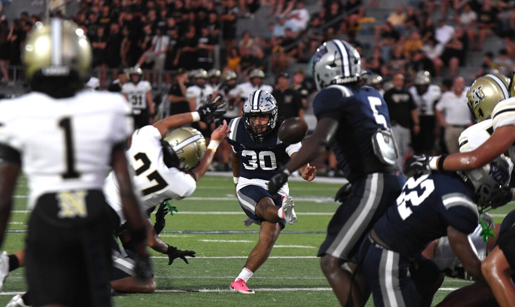 #30 kicking a field goal through a window of other players