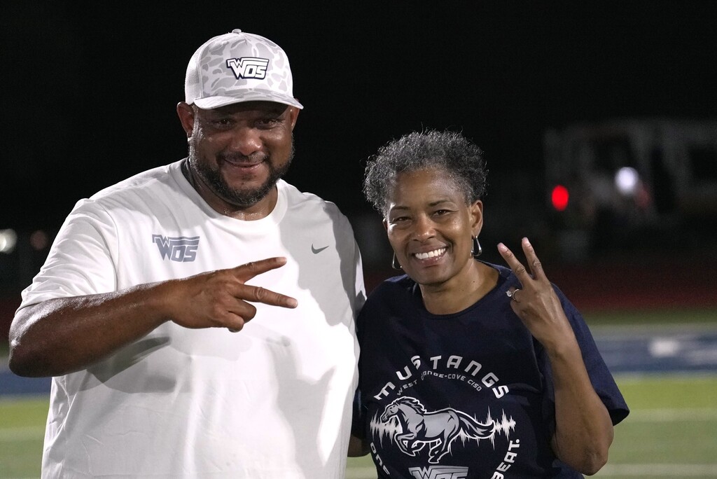 Coach Hickman and Dr. Sigee holding up peace signs
