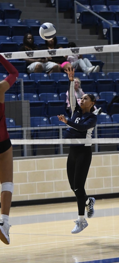 WOS volleyball player hitting ball over the net