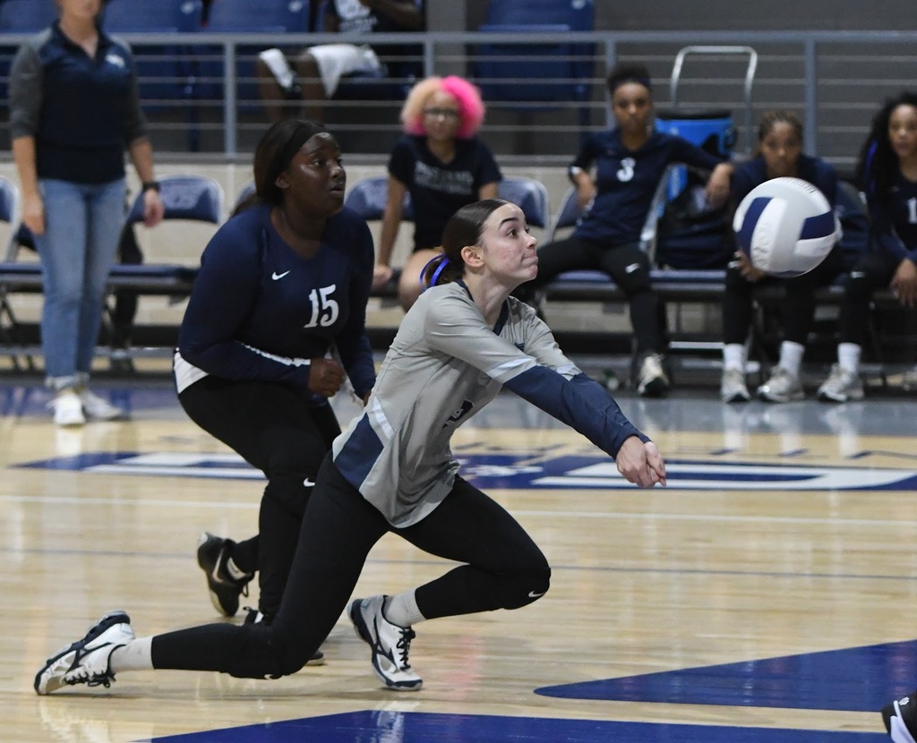 WOS volleyball player lunging to hit ball