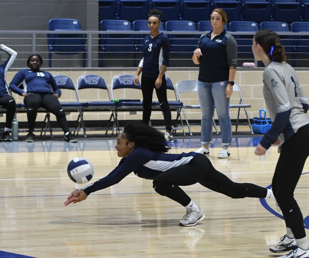 WOS volleyball player diving to hit the ball