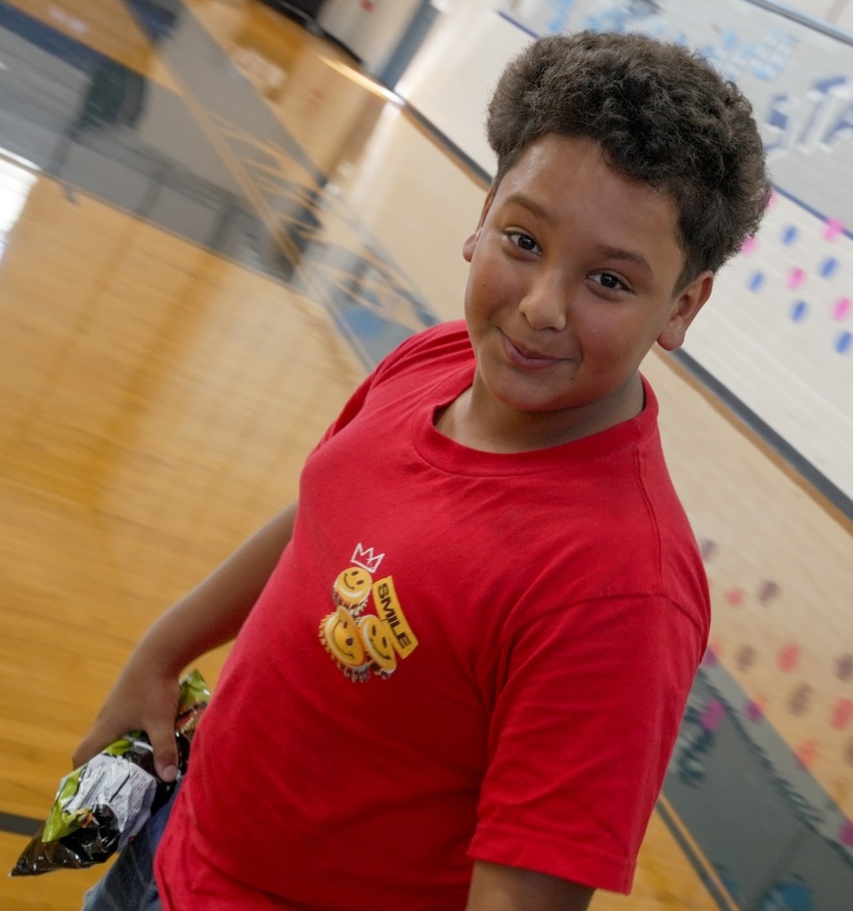 A student in a red shirt looks at the camera