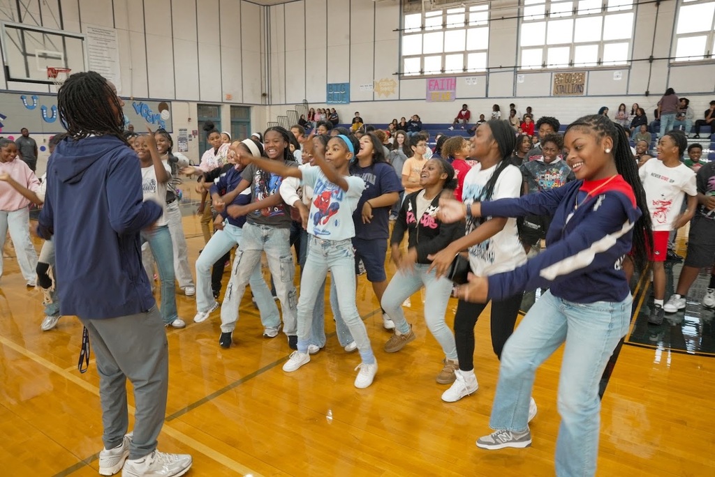 A large group of students dancing in sync in the gym