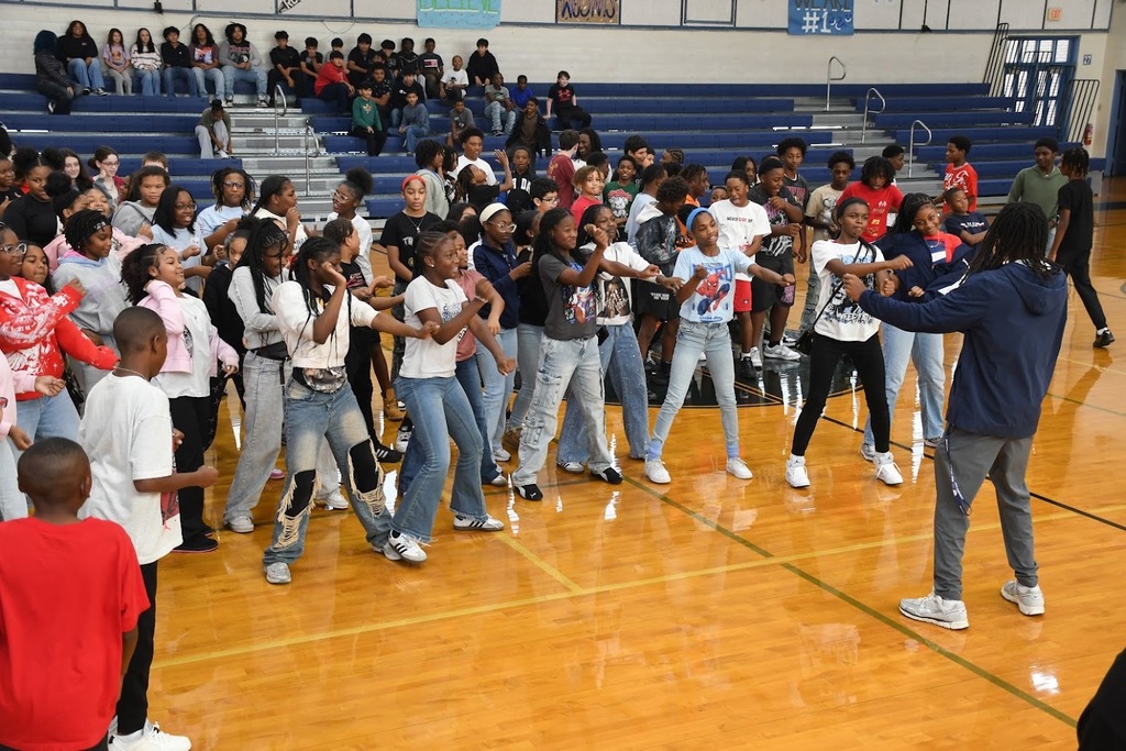 A large group of students dancing in sync in the gym