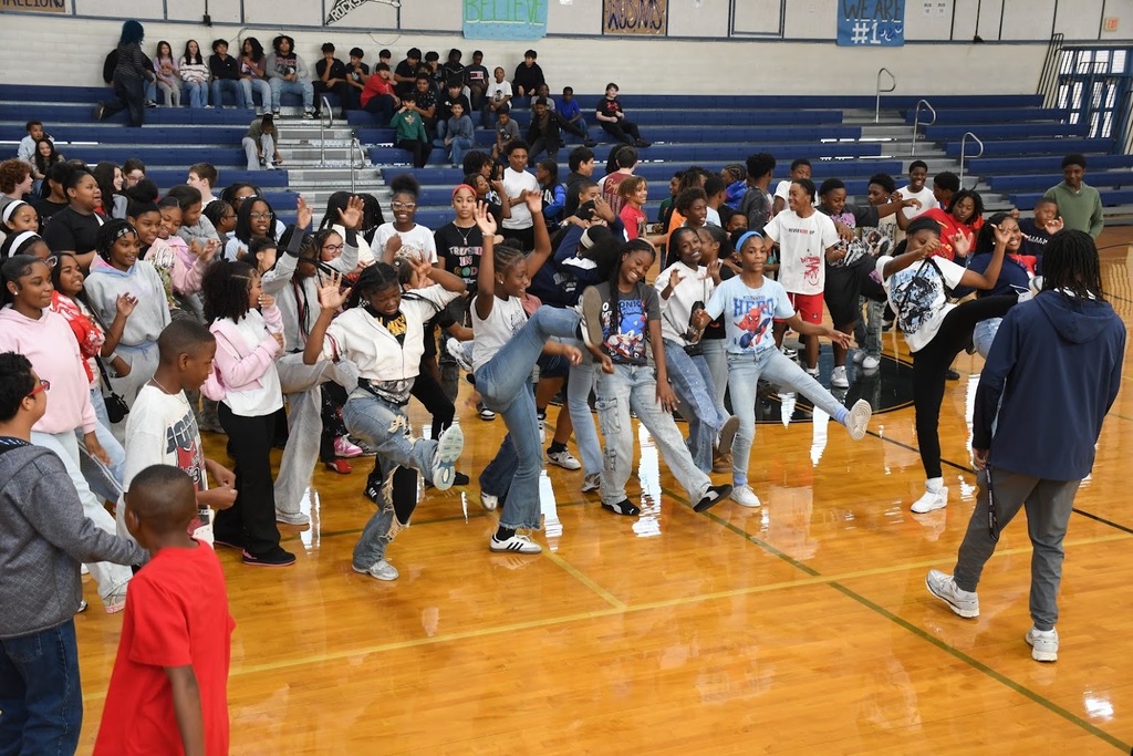 A large group of students dancing in sync in the gym
