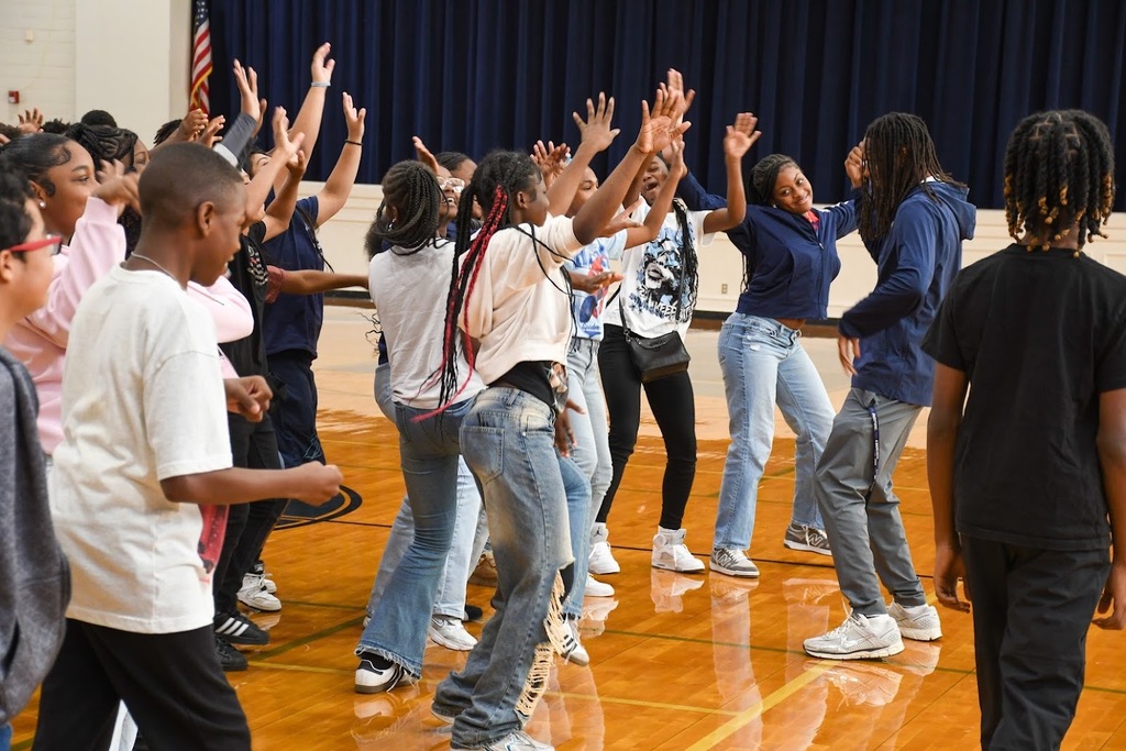 A large group of students dancing in sync in the gym