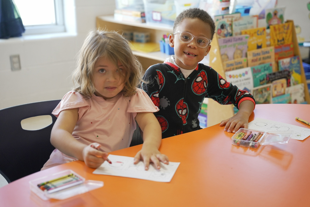 a boy and a girl working on coloring