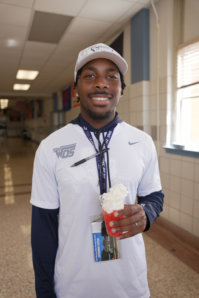 coach smiling and holding a dirty soda