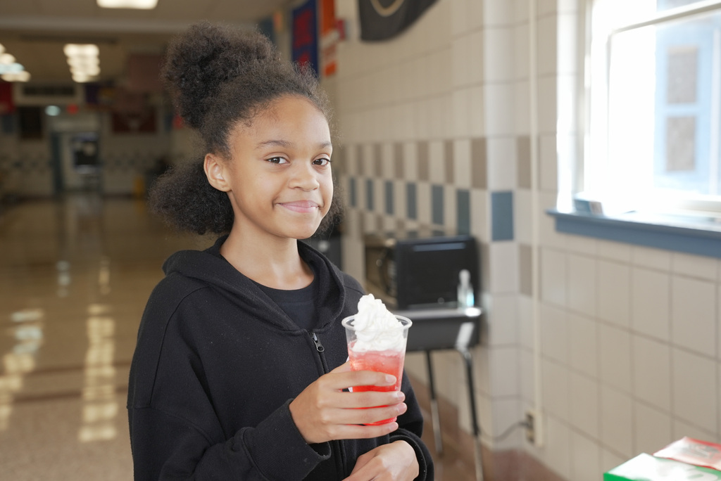 Girl holding a strawberry dirty soda and smiling