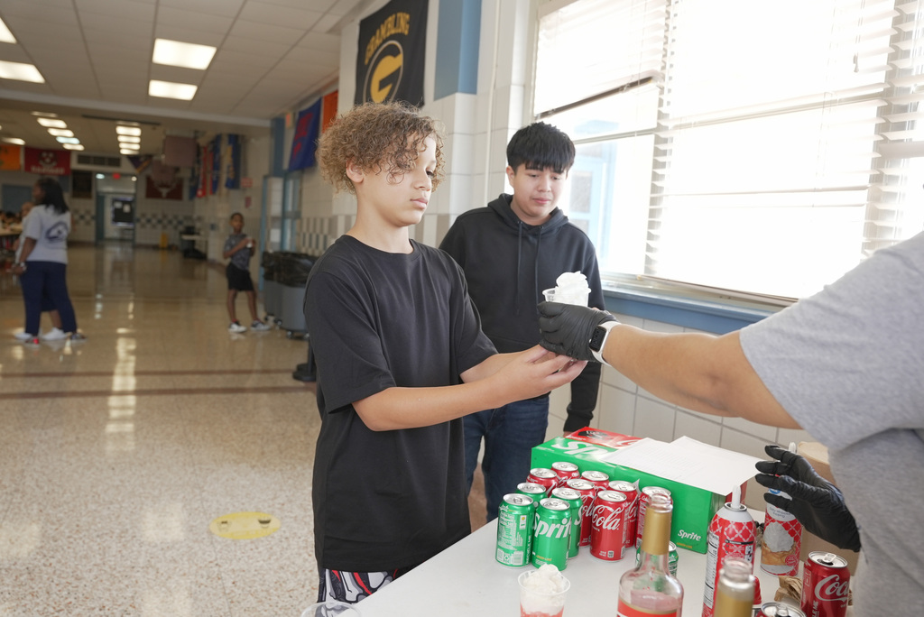 Mrs . Myers handing out a dirty soda to a student