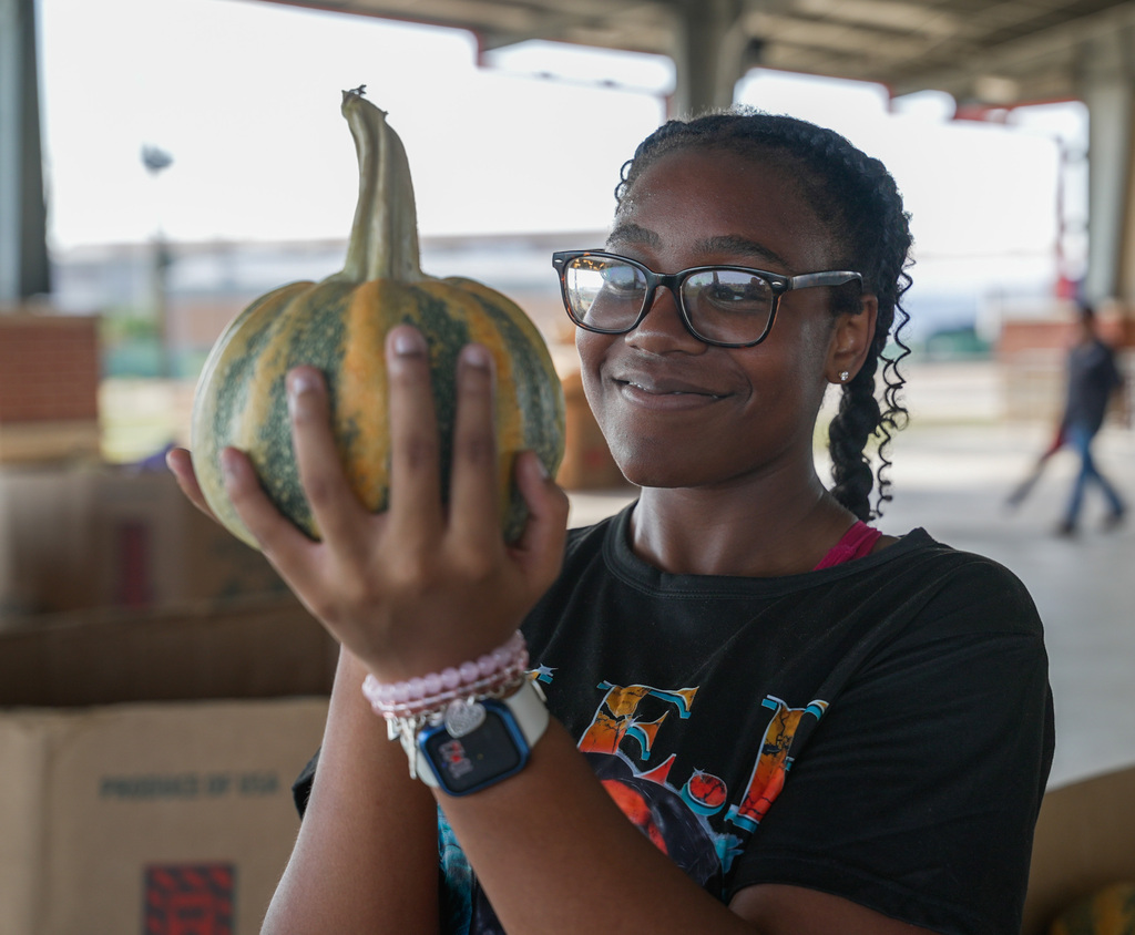 student admiring a pumpkin