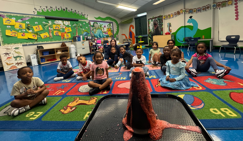 students smiling at a volcano experiment