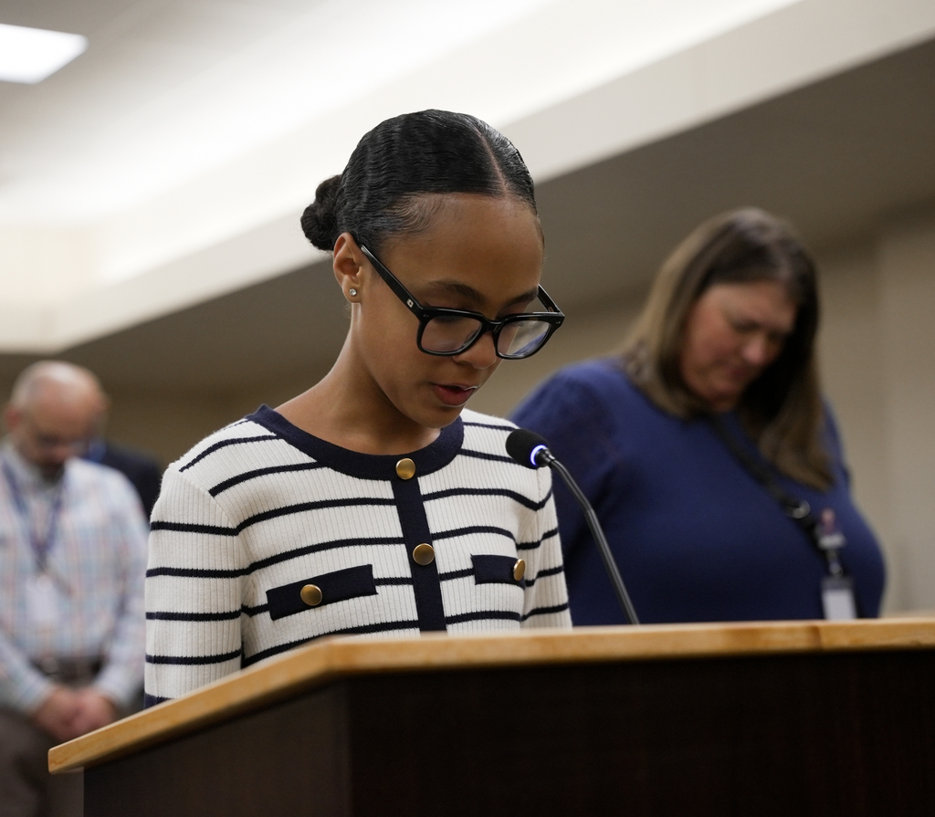 Student Chealsy Mulhollan leads attendees in prayer