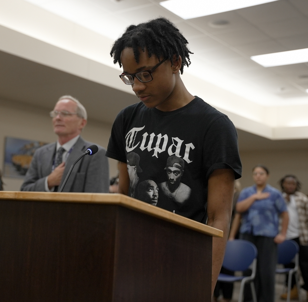 Student Jaiden Ross leads attendees in Pledge of Allegiance