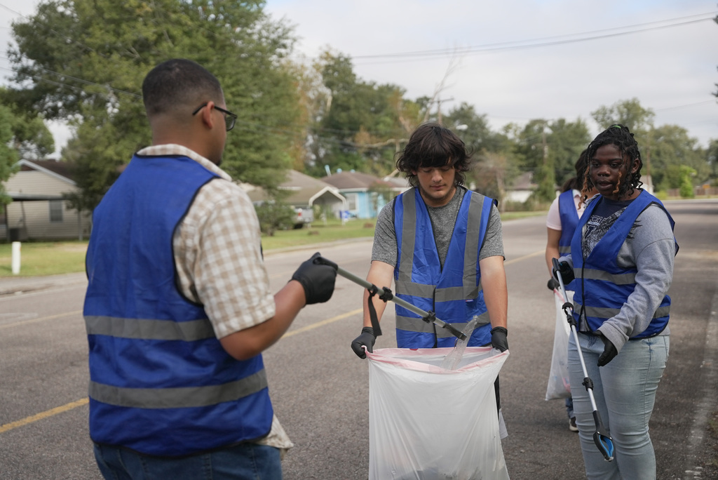 students depositing trash in bag