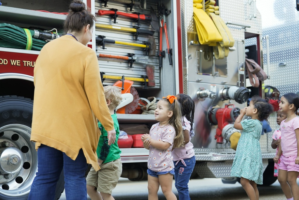 a group of students walking around a firetruck