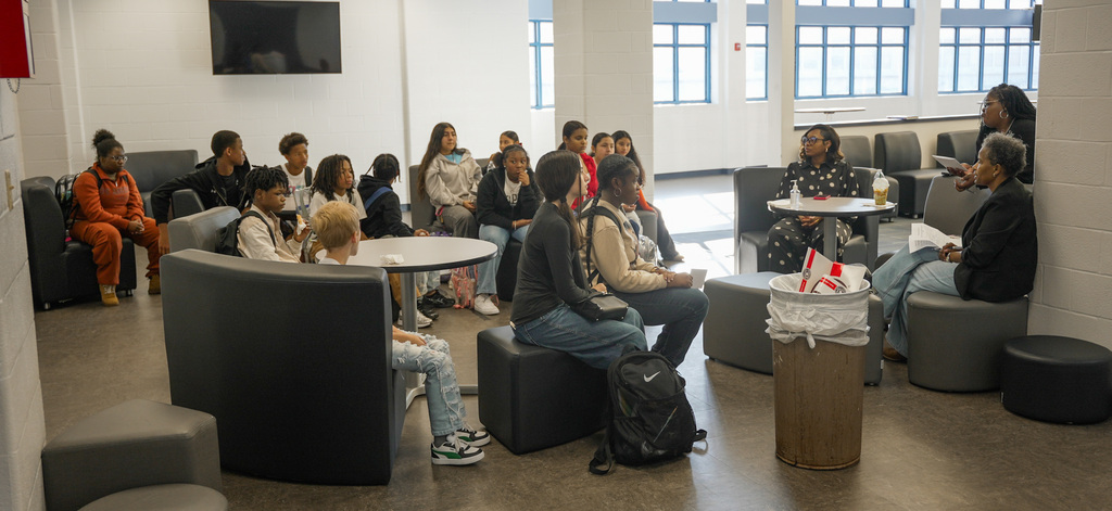 Wide shot of all the students participating in the roundtable seated at the library