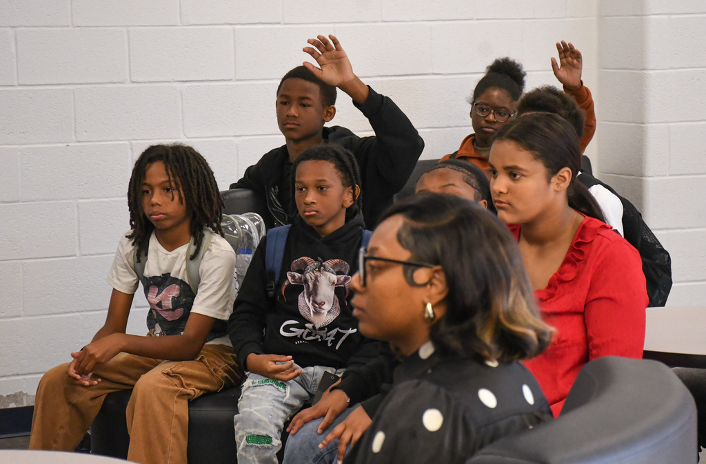 students in a small group raising their hands