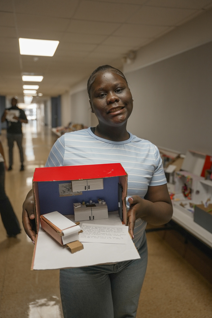 Student holding up a shoebox display of a doctor's office