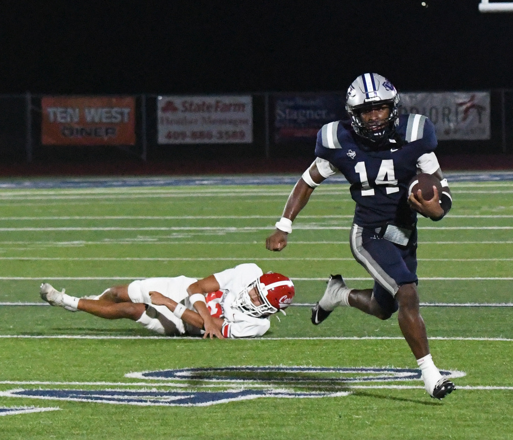 #14 running with the ball away from a fallen defender