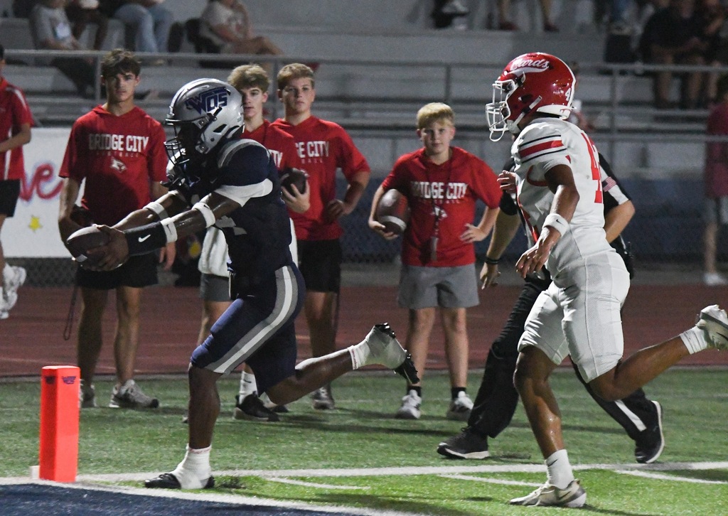 player holding football out over the touchdown line