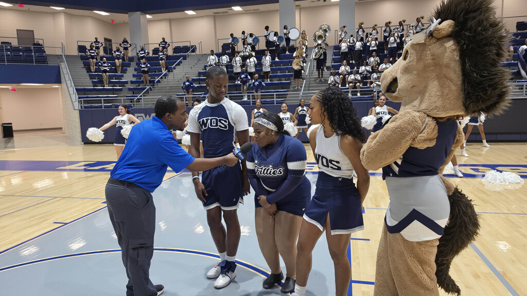Reporter interviewing a cheerleaders and Fillie with WOS Mascot