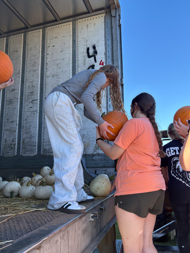 students unloading pumpkins from trailer