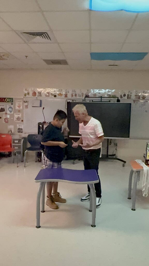 Kevin Spencer facing and talking to a student, both behind a small table