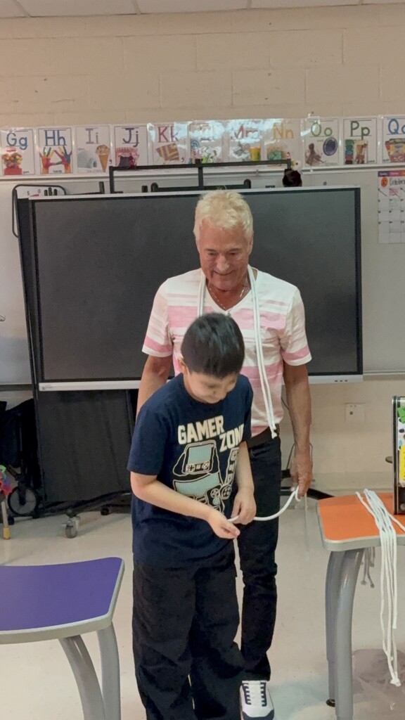 Kevin Spencer and a student playing with piece of string