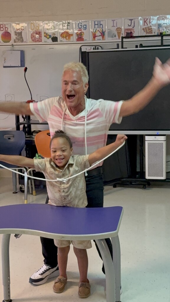 Kevin Spencer and a student having fun during a string activity