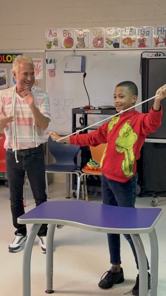 a student playing with string with Kevin Spencer