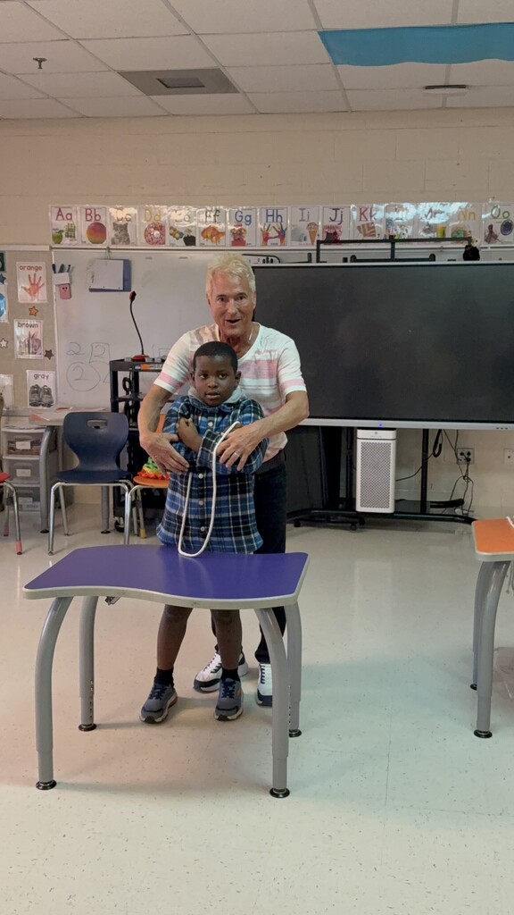 Kevin Spencer helping a student with string