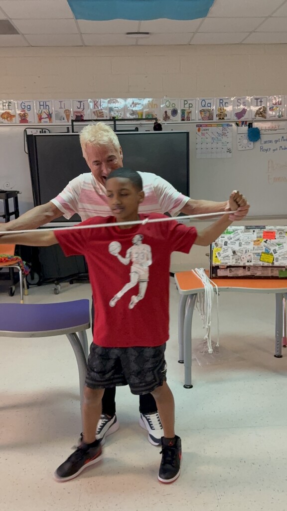 Kevin Spencer helping a student stretch a piece of string