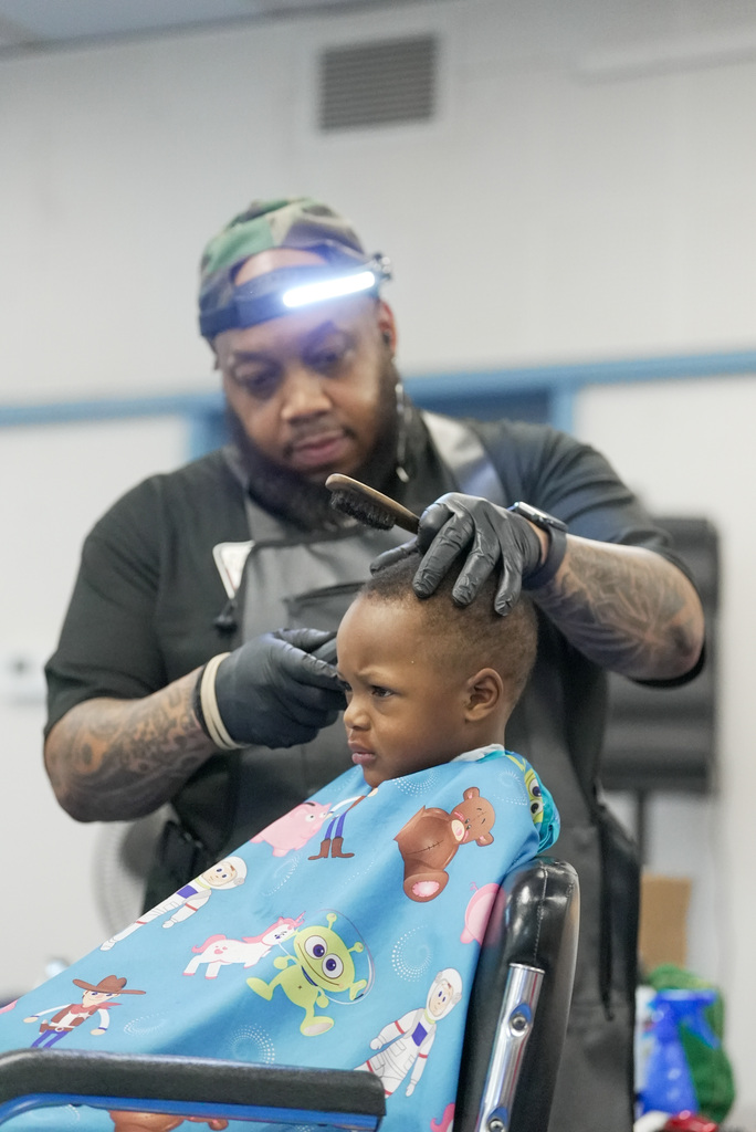 boy getting his haircut by a barber