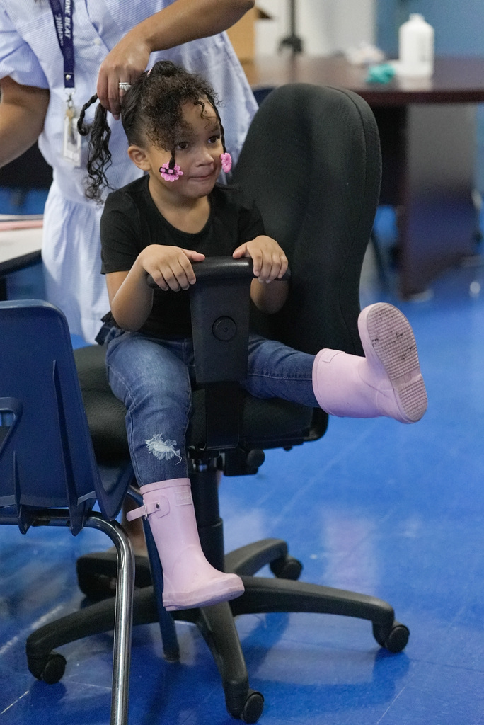 a girl getting her hair done kicking up a rainboot