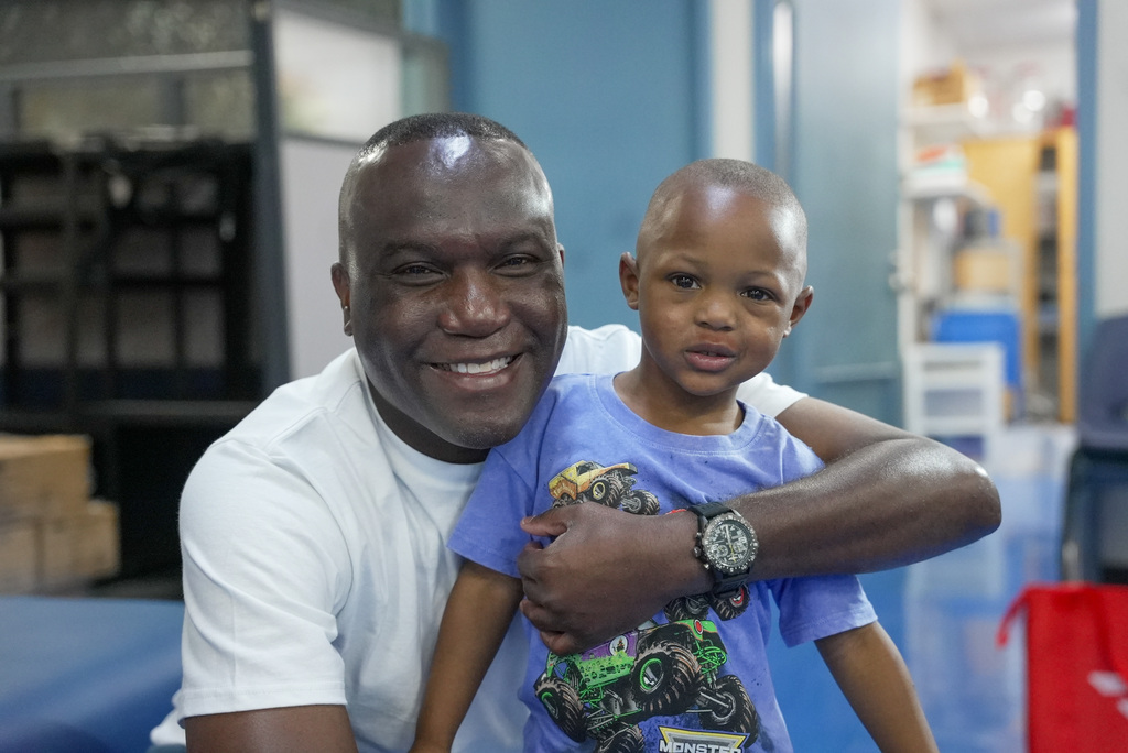 a man hugging a boy with a fresh haircut