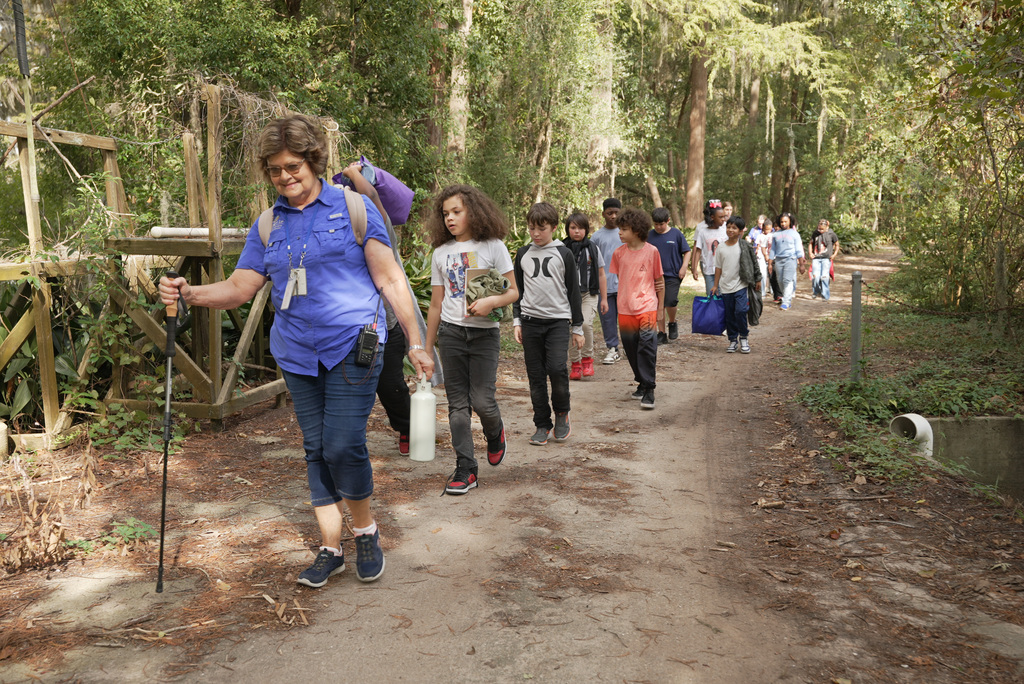 guide leading students down hiking path
