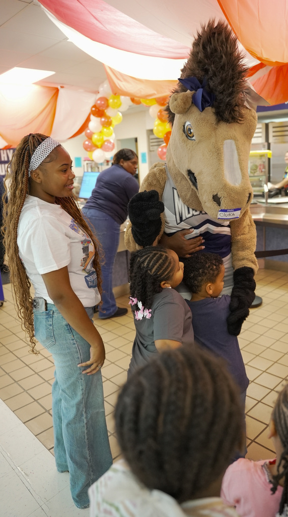 WOSHS Mascot Clutch hugs children in the lunch line