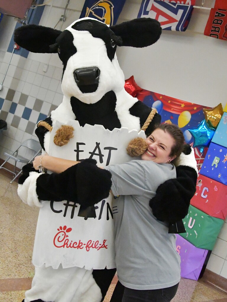 WOSMS teacher hugging Cow mascot