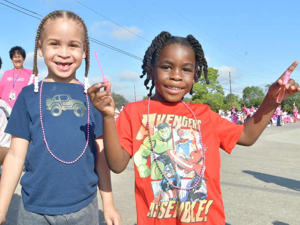 Two boys one wearing blue one wearing red marching in Pinkout Parade