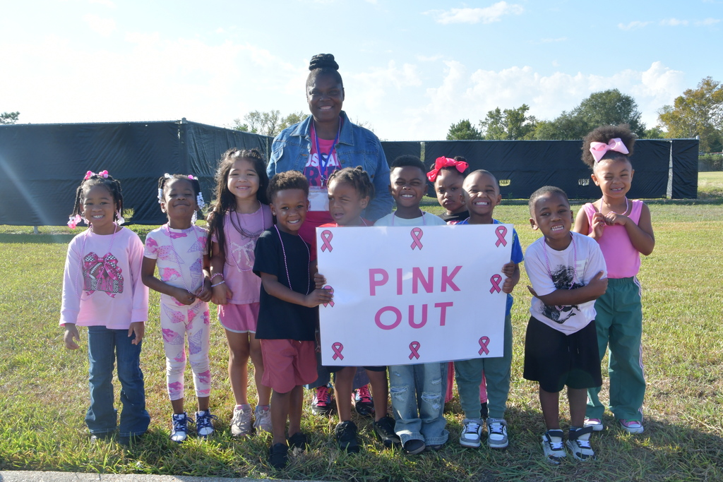 Kids and teacher with a pinkout sign