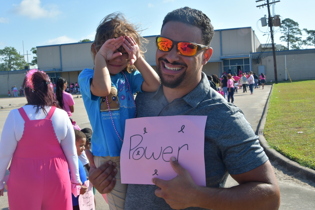 Dad and child holding a pinkout sign