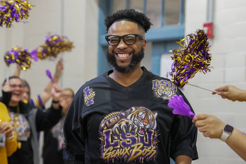 principal smiling as teachers celebrate around him