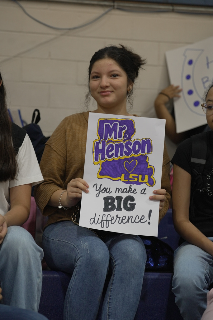 student holding up a sign supporting the principal