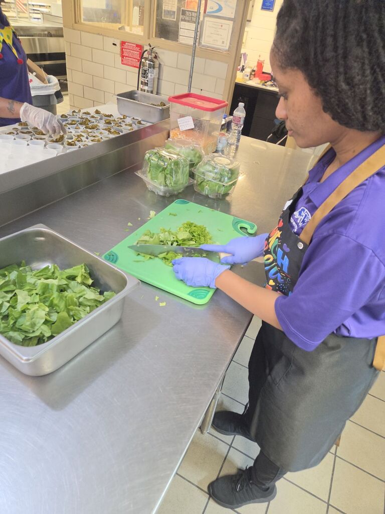 Cafeteria lady chopping lettuce