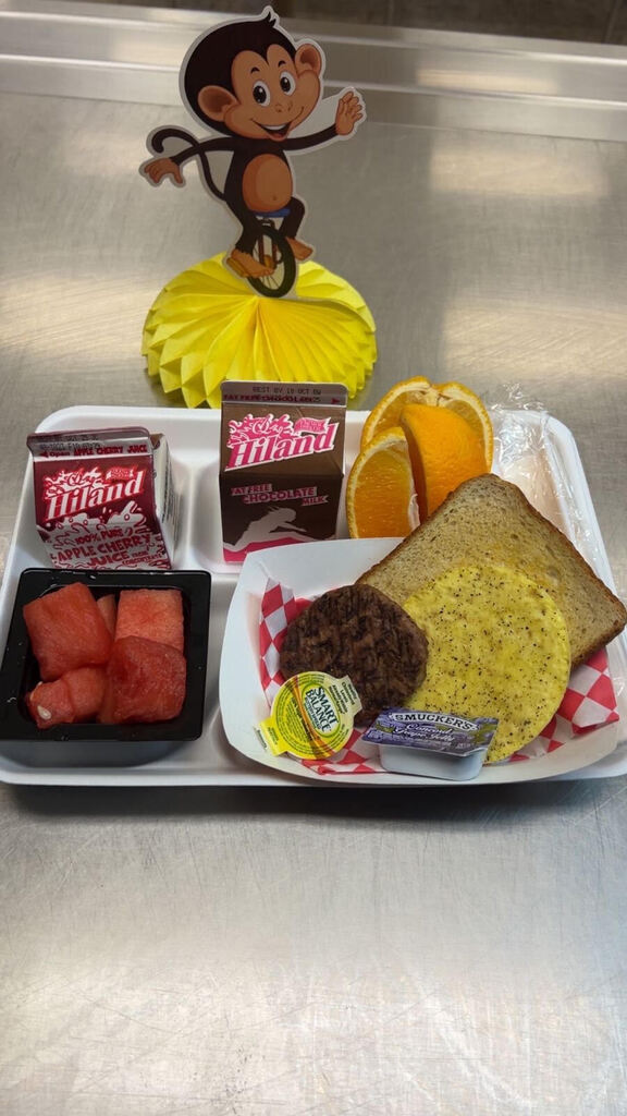 Breakfast try with sausage, eggs, toast, and watermelon