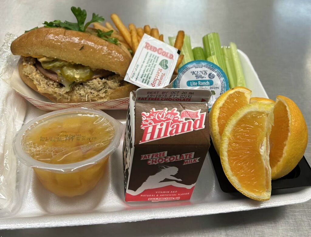 Chicken Cubano sandwich with orange slices and chocolate milk